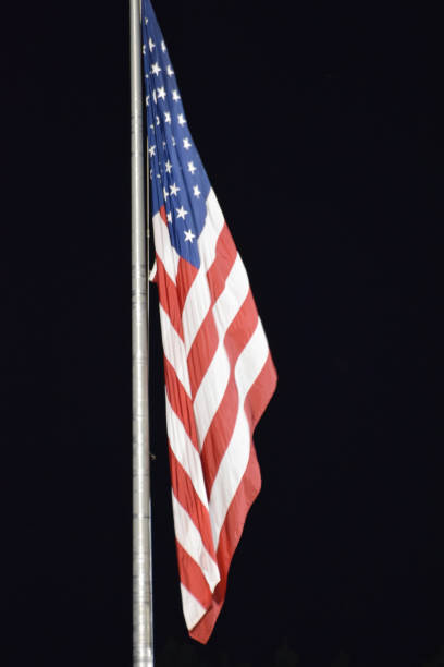 istock American Flag on Pole at Night 1014852472