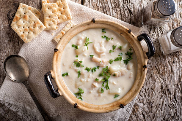 Fish Chowder A delicious creamy white fish chowder with haddock, cod, potato, and onion garnished with parsley and served with soda crackers. Chowder stock pictures, royalty-free photos & images
