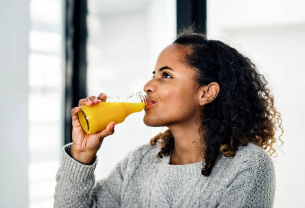 istock Woman drinking fresh orange juice 1014855632
