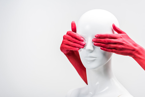 cropped image of woman in red paint covering mannequin eyes isolated on white