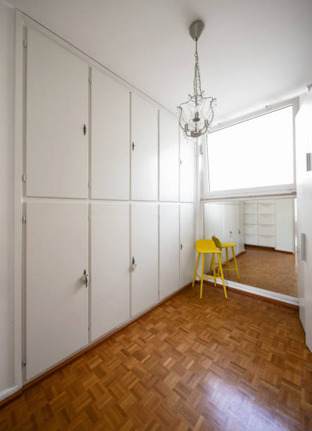 istock Room with white cabinets and a yellow stool 1014857756