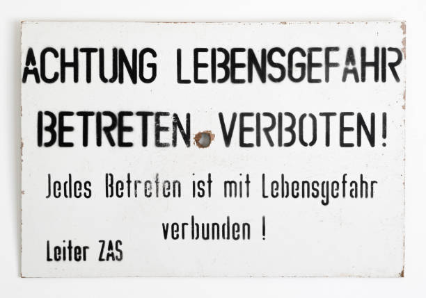 ost - west-deutschen grenze warnschild auf einer weißen wand - west berlin stock-fotos und bilder