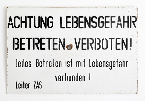 East - West German border warning sign on a white wall