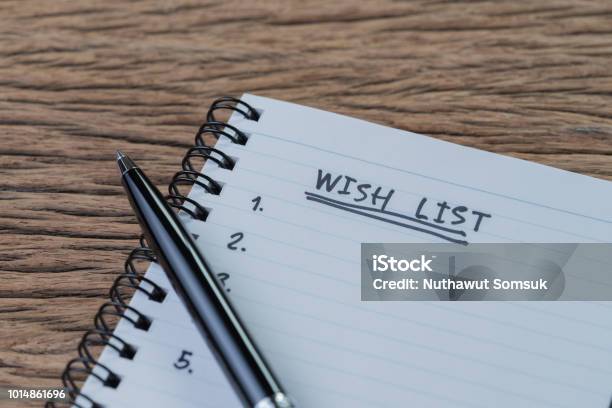 Wish List Concept Pen On White Paper Note Pad With Handwritten Headline As Wish List And Numbers Listed On Wood Table In Soft Tone Things Wanted Or Next Time Purchase Stock Photo - Download Image Now
