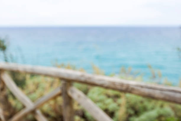 Seascape in summer evening. Wooden fence on the embankment