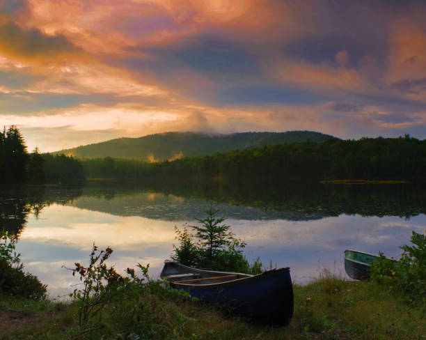 活気に満ちた日の出中に海岸でカヌー/アディロンダック山地の夕日。 - adirondack mountains ストックフォトと画像