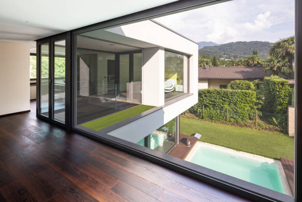 istock Large window in hallway of modern villa overlooking the private pool 1014884036