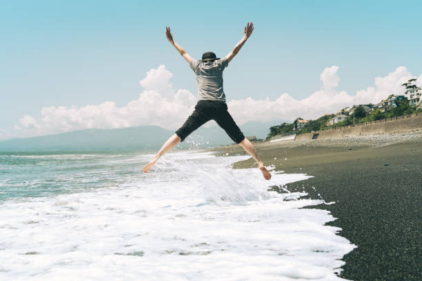 A woman jumping on the beach.