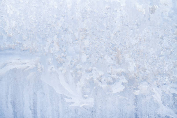 istock Winter frosty patterns on the frozen ice window 1014884818
