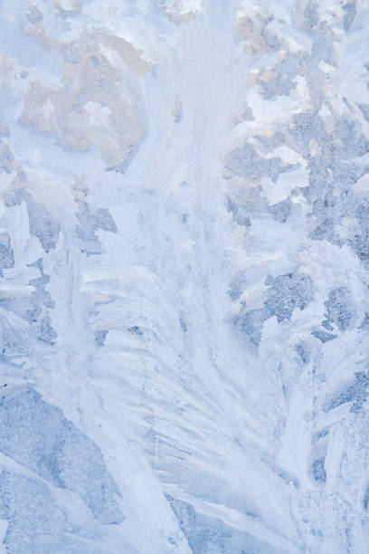 istock Winter frosty patterns on the frozen ice window 1014887358
