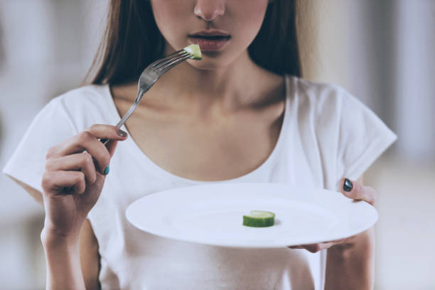 istock Young Thin Girl Eat Cucumber. 1014887812