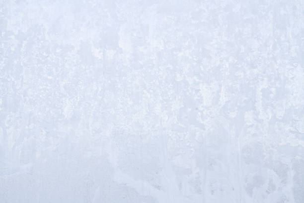 Frozen pattern of hoarfrost and frostwork structure on the dark glass. Color photo for background.