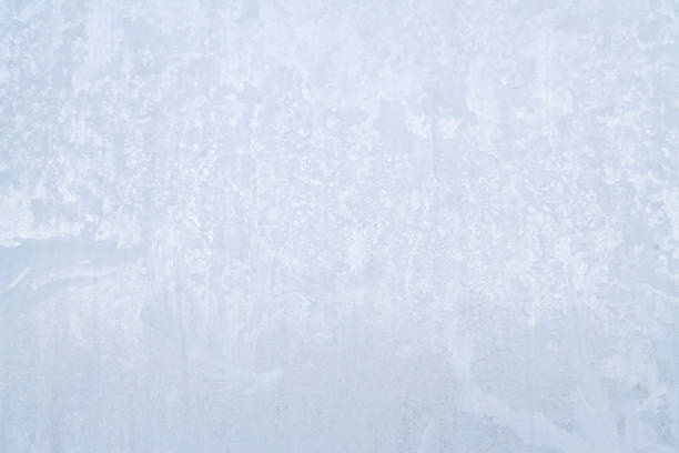 istock Winter frosty patterns on the frozen ice window 1014888746