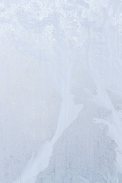 istock Winter frosty patterns on the frozen ice window 1014890974