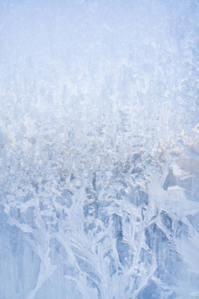 istock Winter frosty patterns on the frozen ice window 1014891074