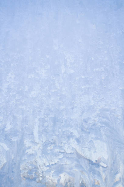 istock Winter frosty patterns on the frozen ice window 1014891102