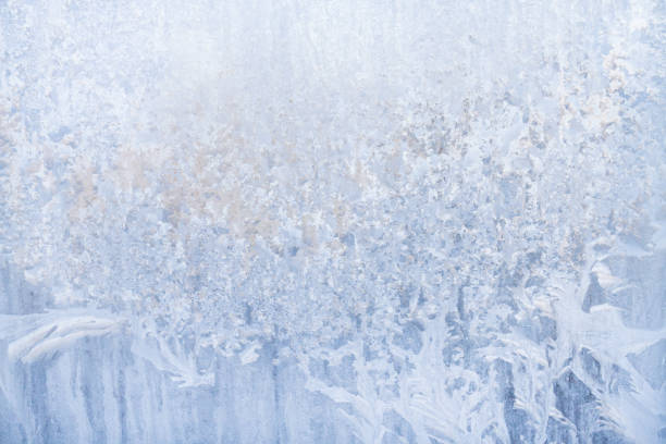istock Winter frosty patterns on the frozen ice window 1014891174