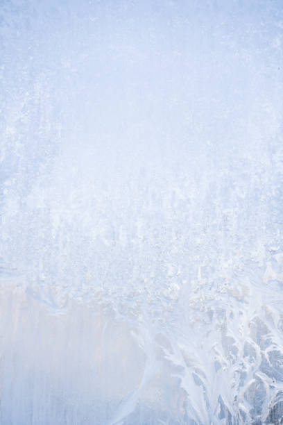 istock Winter frosty patterns on the frozen ice window 1014891294