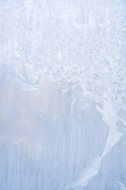 istock Winter frosty patterns on the frozen ice window 1014891426