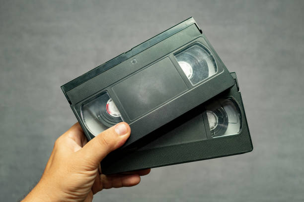 istock two analogue video cassettes for home use in a hand on a gray background 1014891502