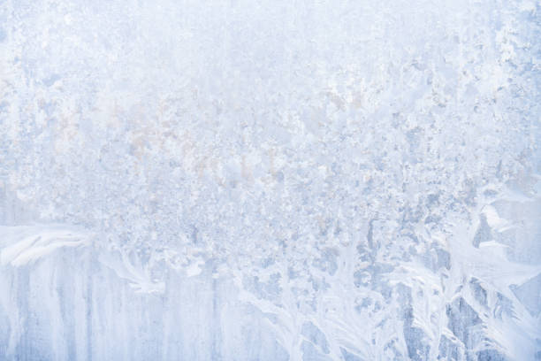 istock Winter frosty patterns on the frozen ice window 1014891844