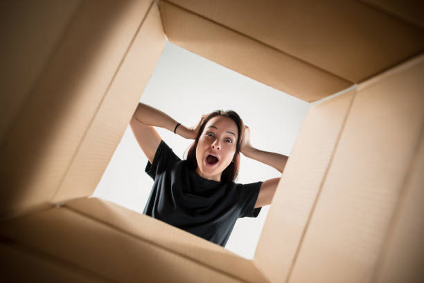 istock Woman unpacking and opening carton box and looking inside 1014897822