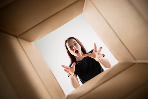 istock Woman unpacking and opening carton box and looking inside 1014898110