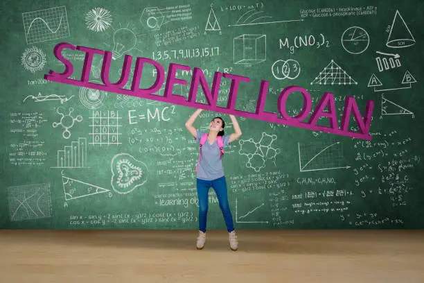 Picture of female college student lifting student loan word while standing in the classroom