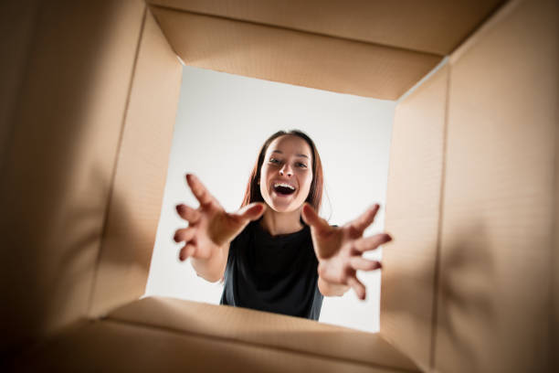istock Woman unpacking and opening carton box and looking inside 1014898216