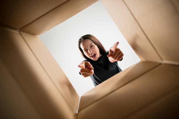 istock Woman unpacking and opening carton box and looking inside 1014898432