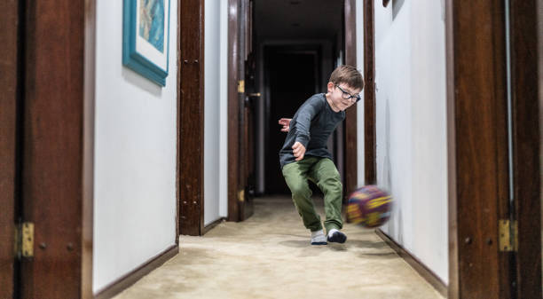 kleiner junge spielt mit dem ball zu hause - soccer child indoors little boys stock-fotos und bilder