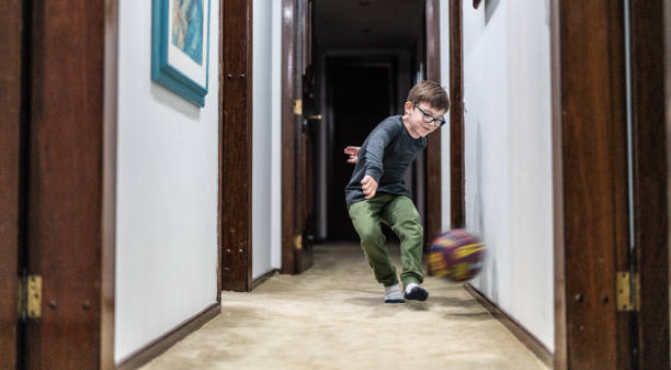 маленький мальчик, играющий с мячом дома - soccer child little boys playing стоковые фото и изображения