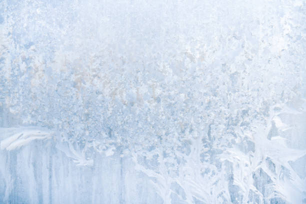 istock Winter frosty patterns on the frozen ice window 1014903120
