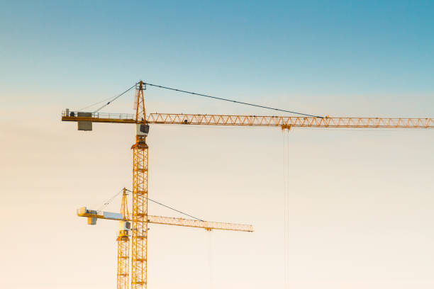 istock Construction cranes at a construction site at sunset in early spring 1014903316