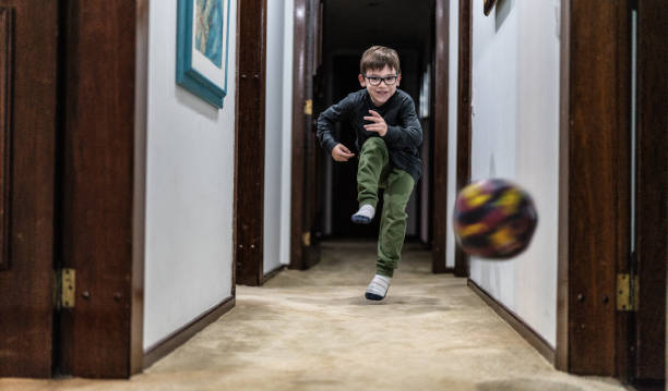 bambino che gioca con la palla a casa - soccer child indoors little boys foto e immagini stock
