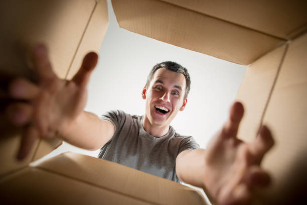 istock Man unpacking and opening carton box and looking inside 1014903580