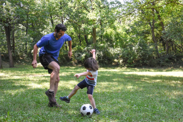 istock Father and son play with ball in autumn park 1014903738