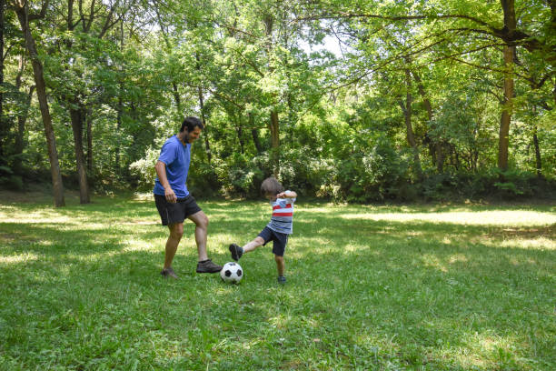 istock Father and son play with ball in autumn park 1014909030