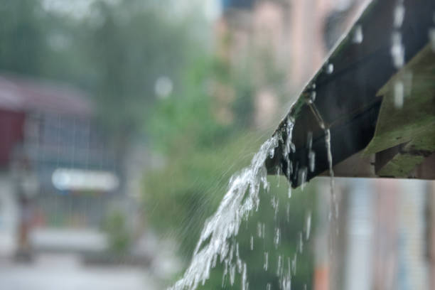 istock Storm rain drips down from the roof with a powerful stream 1014921046