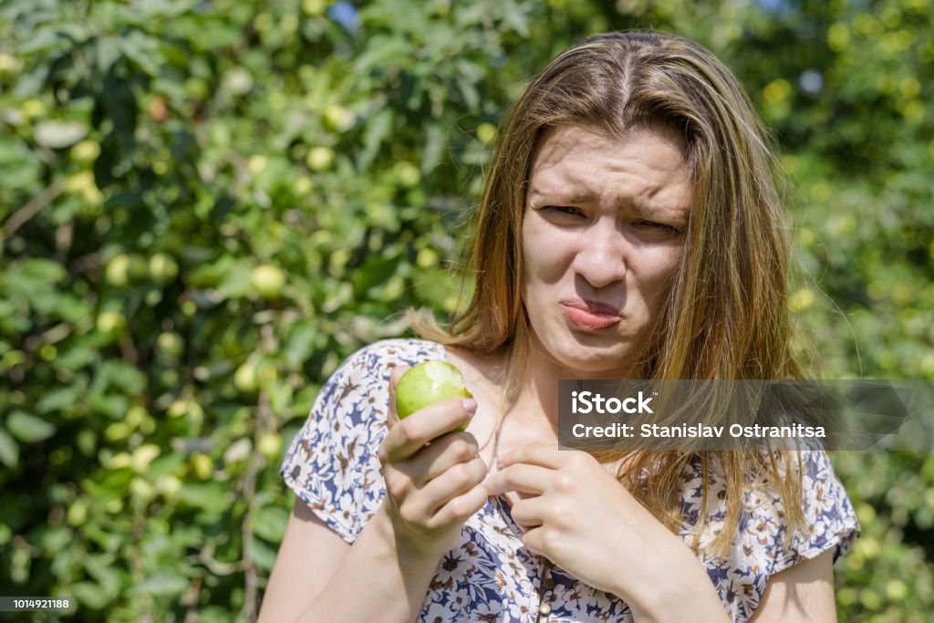 Jeune femme a mangé la pomme immature - Photo de Femmes libre de droits