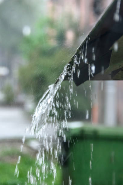 istock Storm rain drips down from the roof with a powerful stream 1014921358