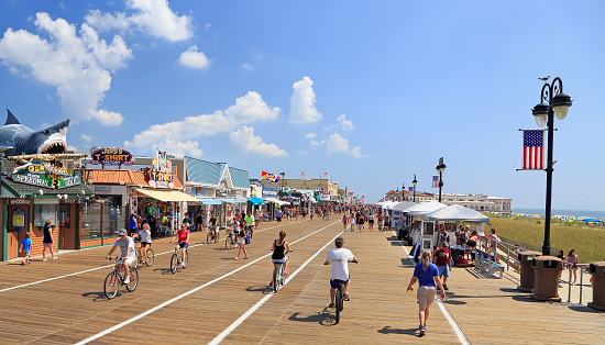 Ocean City, New Jersey - August 05, 2018:  People walking and biking along the boardwalk in Ocean City, New Jersey, USA