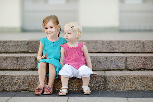 Portrait of two little sisters outdoors at summer