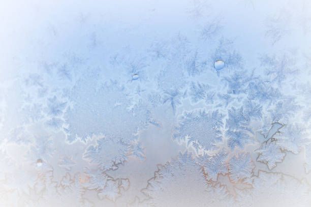 istock Winter frosty patterns on the frozen ice window 1014930374