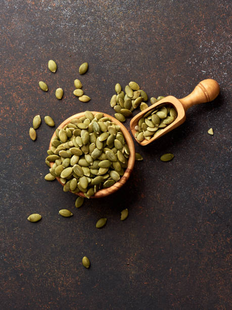 istock Pumpkin seeds on brown background. 1014930398