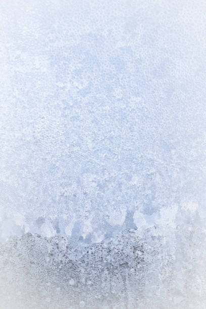 istock Winter frosty patterns on the frozen ice window 1014930710
