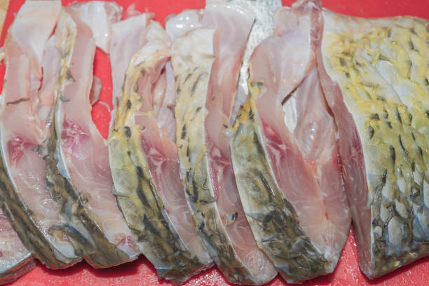 istock Cleaning fresh fish carp from scales with a special knife 1014931082