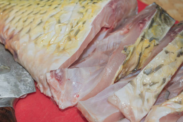 istock Cleaning fresh fish carp from scales with a special knife 1014931086