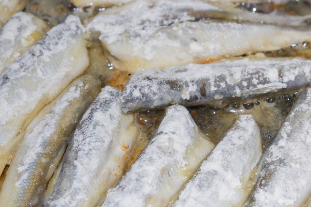 istock Cooking fried fish smelt rolled in flour 1014933940