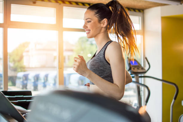 istock Attractive sportswoman on running track machine in gym. 1014939800
